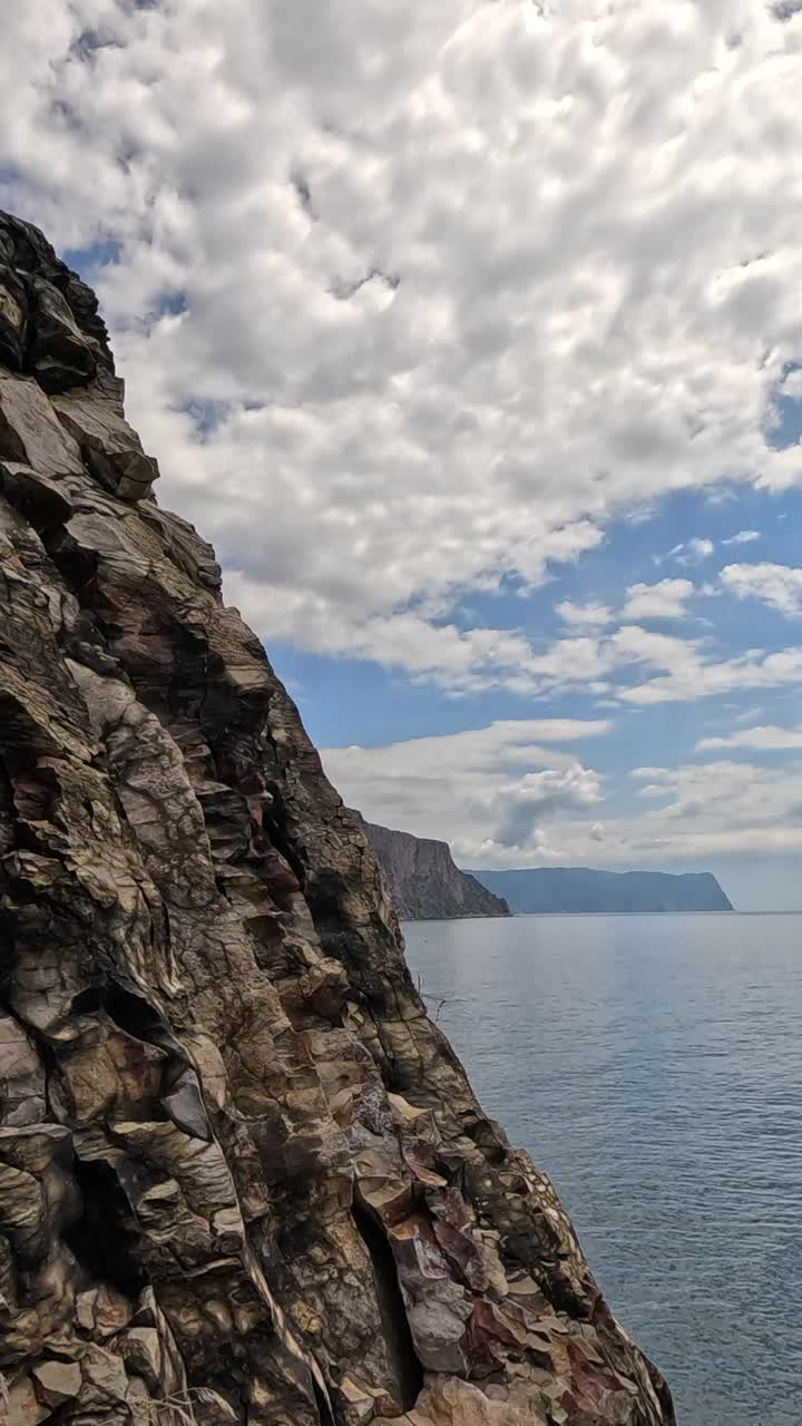 垂直鸟瞰平静蔚蓝的大海和火山岩海岸。小波浪在水面上的运动模糊。自然夏天海洋大海沙滩背景。没有人。度假、度假、旅游的概念视频素材