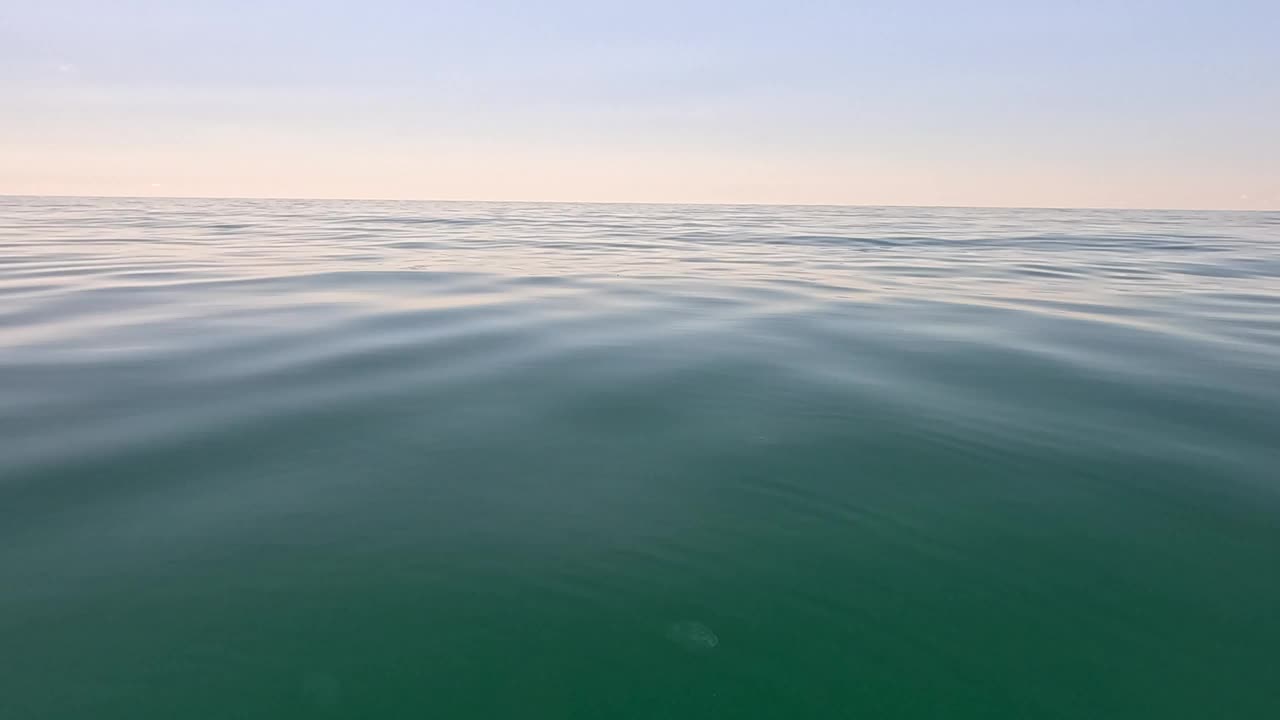 海水表面。低角度俯瞰清澈湛蓝的海水。太阳眩光。抽象航海夏季海洋自然。度假、度假、旅游的概念。没有人。缓慢的运动。天气和气候变化视频素材