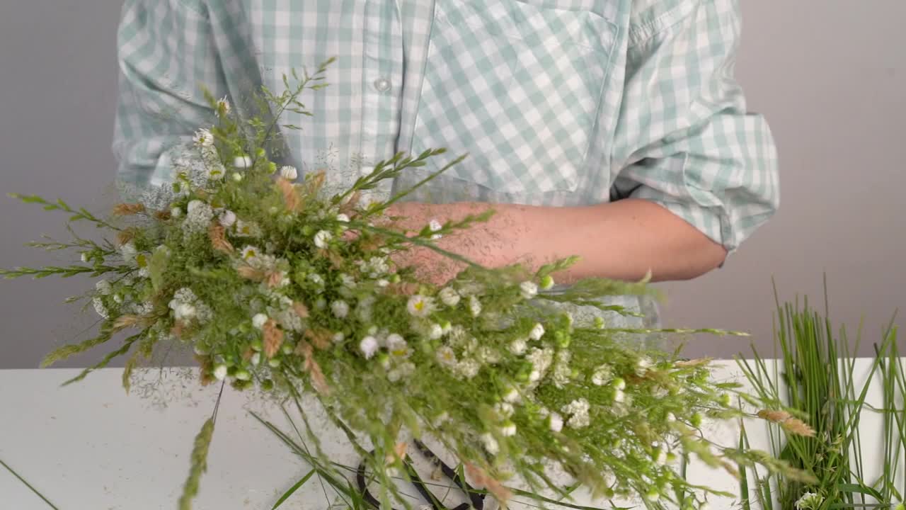 为伊万·库帕拉的盛宴编织花圈的花艺大师班。妇女用新鲜的草药和鲜花编织花环，这是异教徒的象征，冬至日。乡村风格。雏菊和香草的花环，夏天视频素材