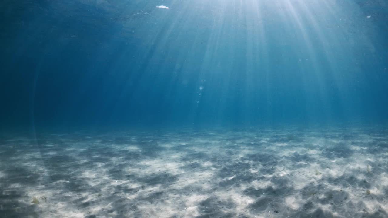 湛蓝透明的海洋，阳光，沙质海底和水下波浪视频素材