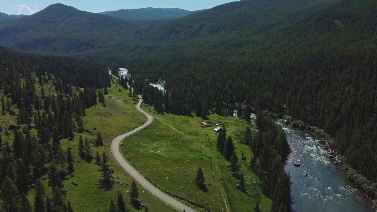 鸟瞰绿色的山景，一条河流从山上流过，美丽的针叶林蔓延开来。视频下载