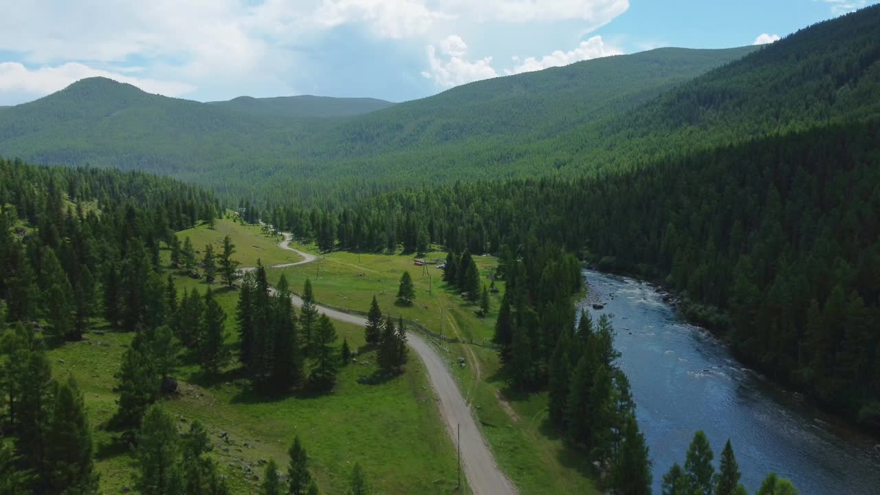 鸟瞰绿色的山景，一条河流从山上流过，美丽的针叶林蔓延开来。视频下载