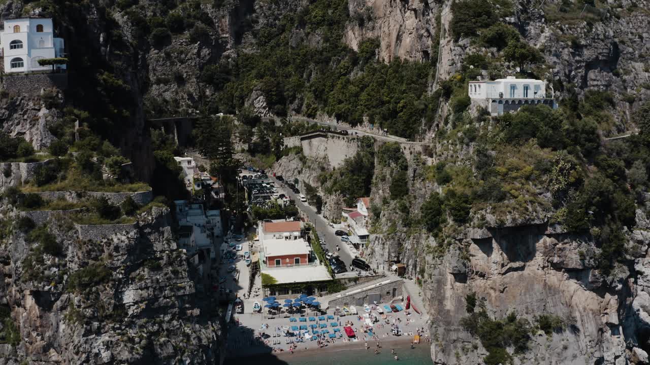 无人机穿过意大利陡峭山脉的照片显示，房屋建在陡峭的斜坡上。视频素材