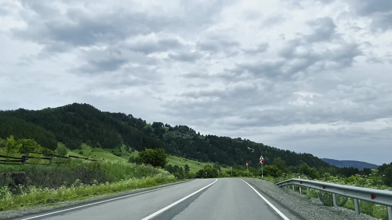 汽车行驶在山路上，景色壮丽。开车旅行。美丽的大自然。视频素材