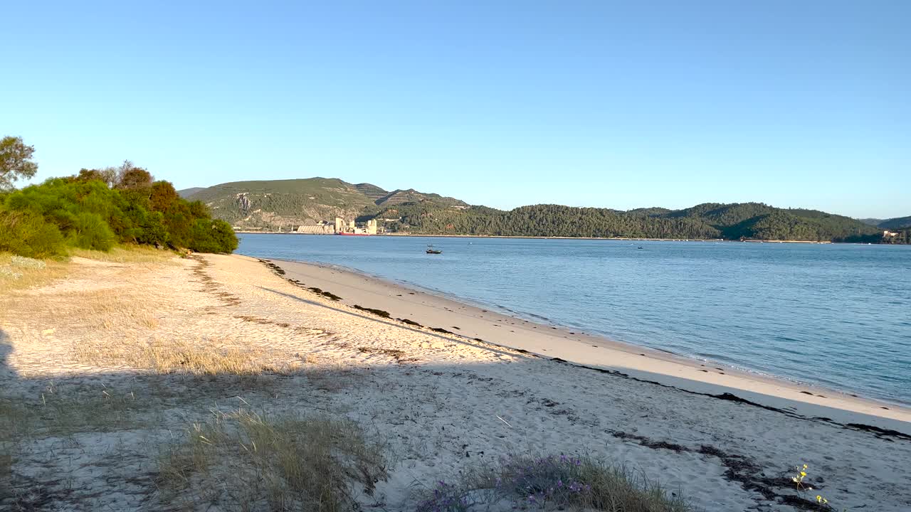 船锚定，漂浮在一个平静和宁静的海洋与Setúbal在背景。视频素材