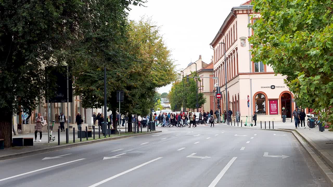 繁忙的街景，人群走过克卢日市的一个十字路口视频素材