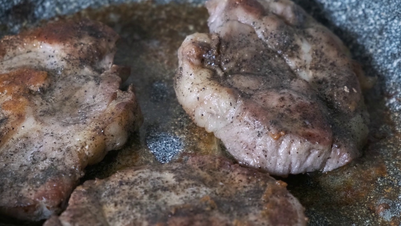 用煎锅煎猪肉排。为晚餐准备食物视频素材