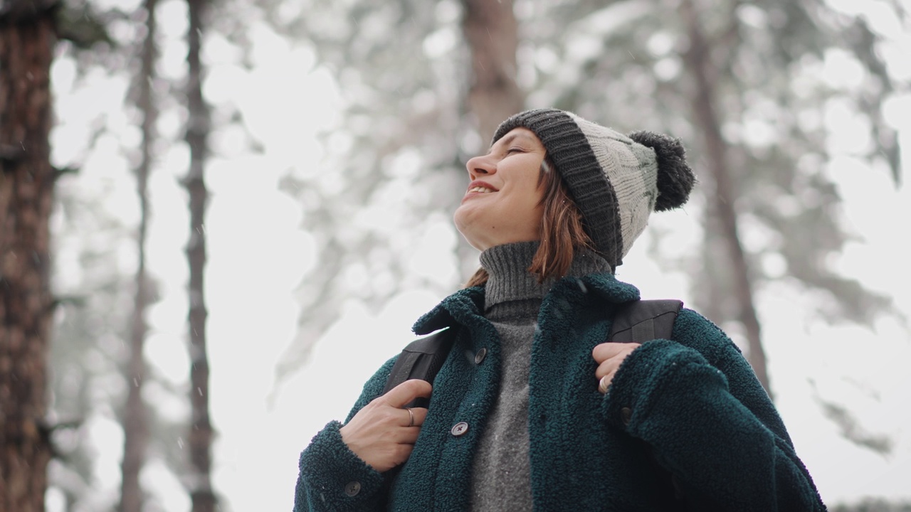 一个成年白人妇女享受降雪的肖像视频素材