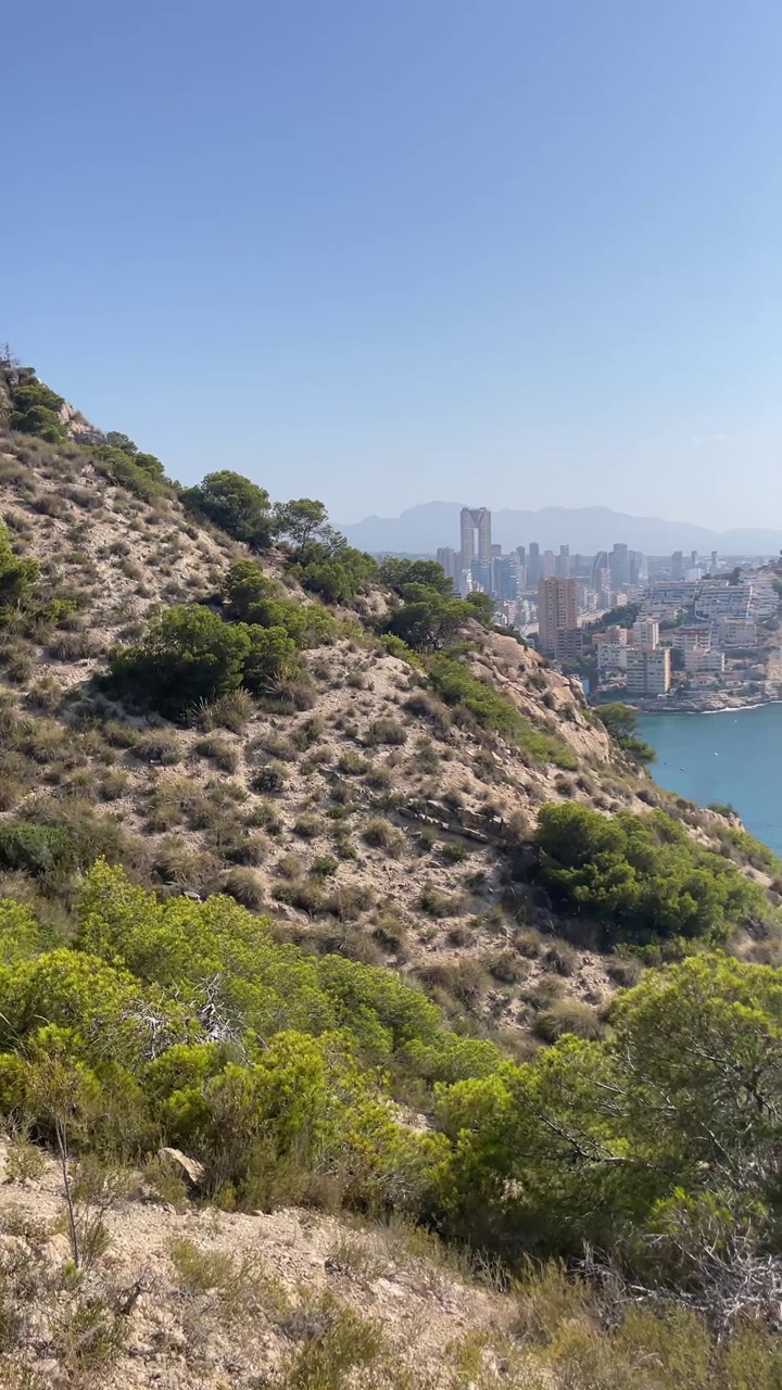 在Cala de Finestrat和Benidorm山上徒步旅行。概念:夏日天堂、海滩、高山之旅。垂直4k慢动作镜头视频下载