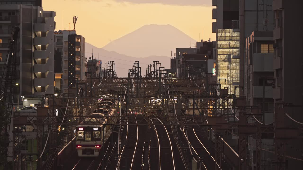 日本日落时分，火车行驶在铁轨上，背景是富士山。日本交通，亚洲通勤生活方式，亚洲旅游视频下载