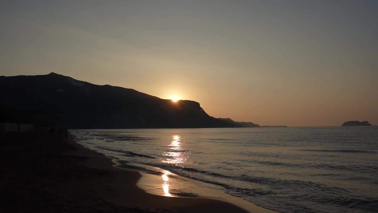 在赞特岛卡拉马基海滩上，太阳在山顶上达到顶峰的视频。视频下载