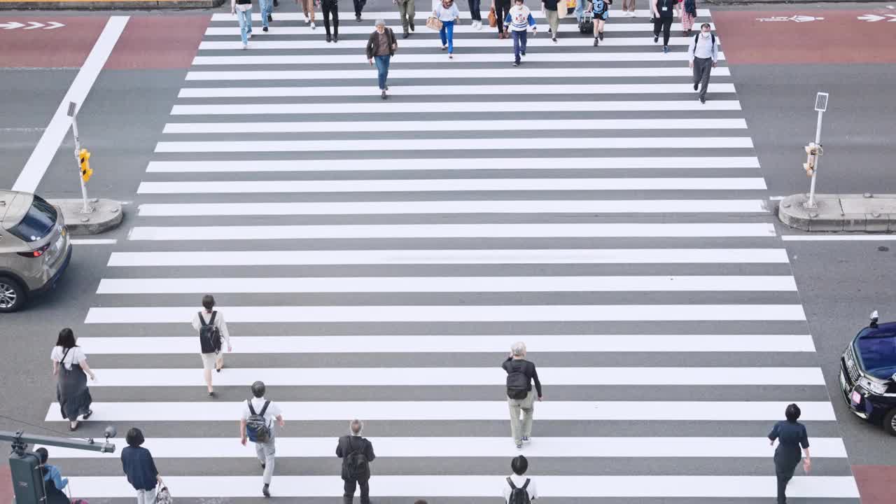 拥挤的日本人，亚洲旅行者走斑马线过马路。日本文化，东京城市生活方式，亚洲交通，通勤交通或城市生活理念。慢动作视频素材