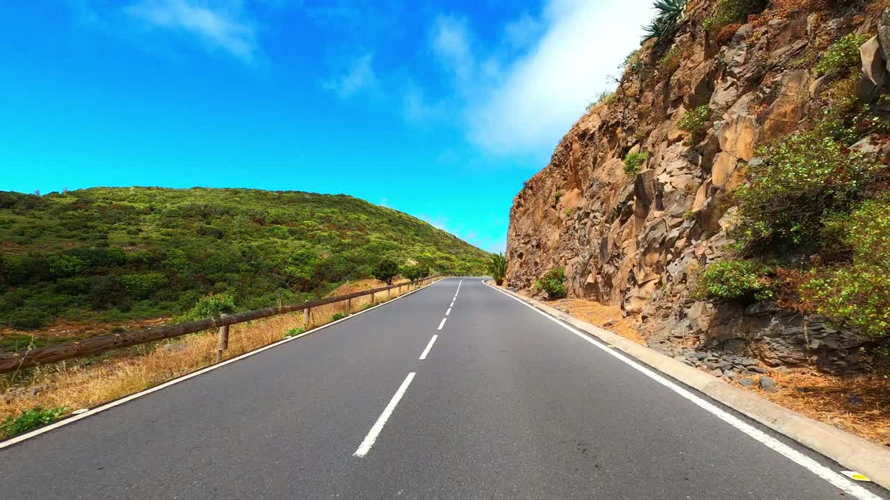 在蓝天和地平线的背景下，在一条长长的柏油直路上开车。旅游和交通的概念。山区国家公园。开车到目的地。节日假期。视频素材