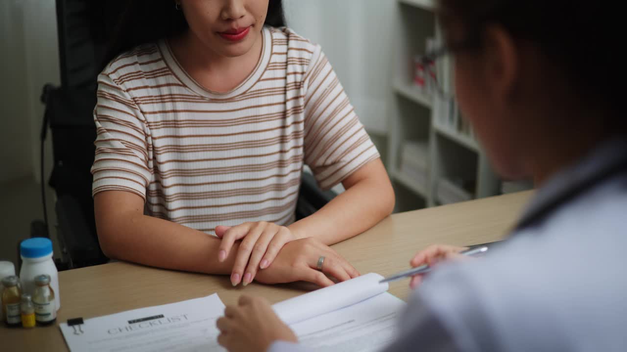 年轻医生在检查室解释女病人的症状视频素材