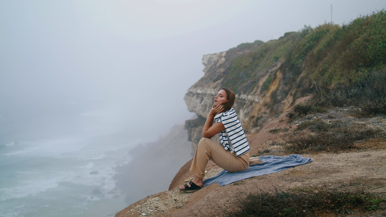 女人在暑假伸展海崖。平静的游客欣赏海景视频素材