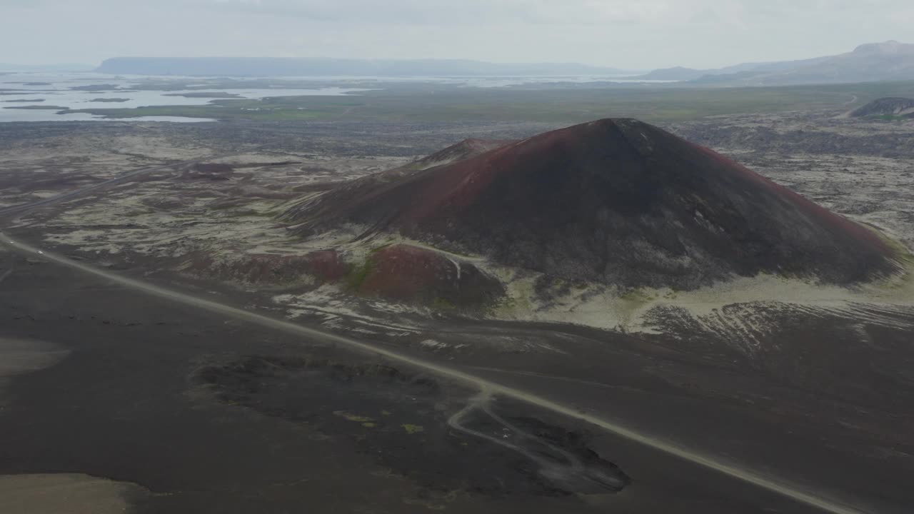 鸟瞰冰岛西部斯奈费尔斯红色火山口和未铺路面的道路。视频素材