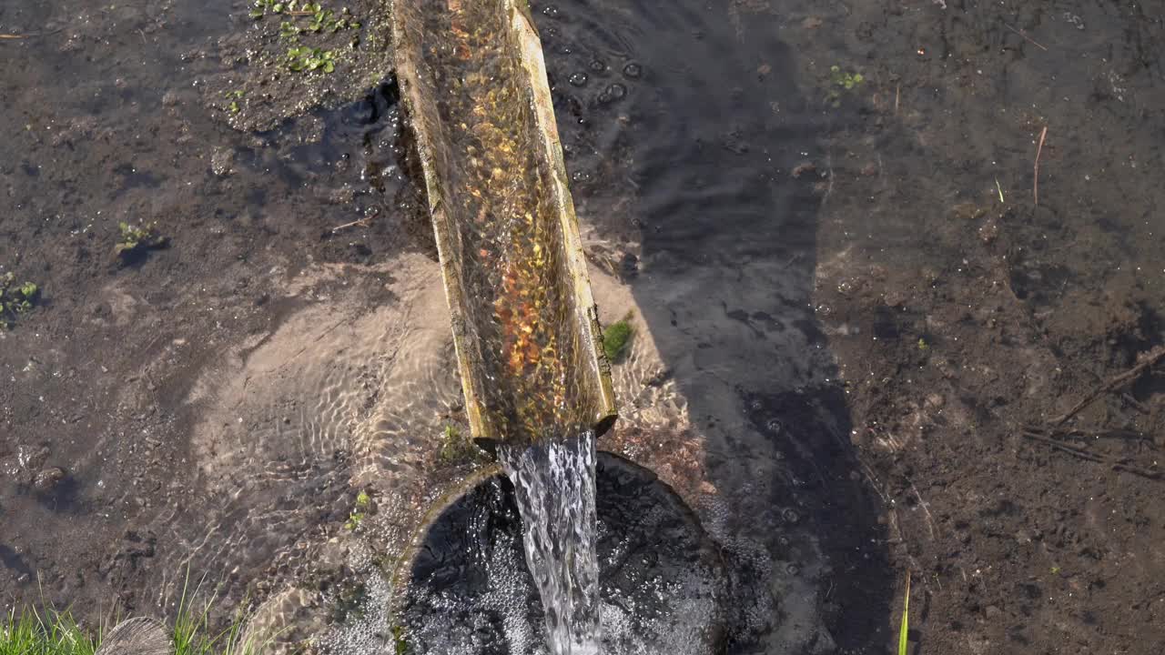 溜槽中古老的天然水源。干净、清新、天然的泉水从木槽中流出。山泉水流经木沟。自然视频片段在4K 25FPS。视频素材