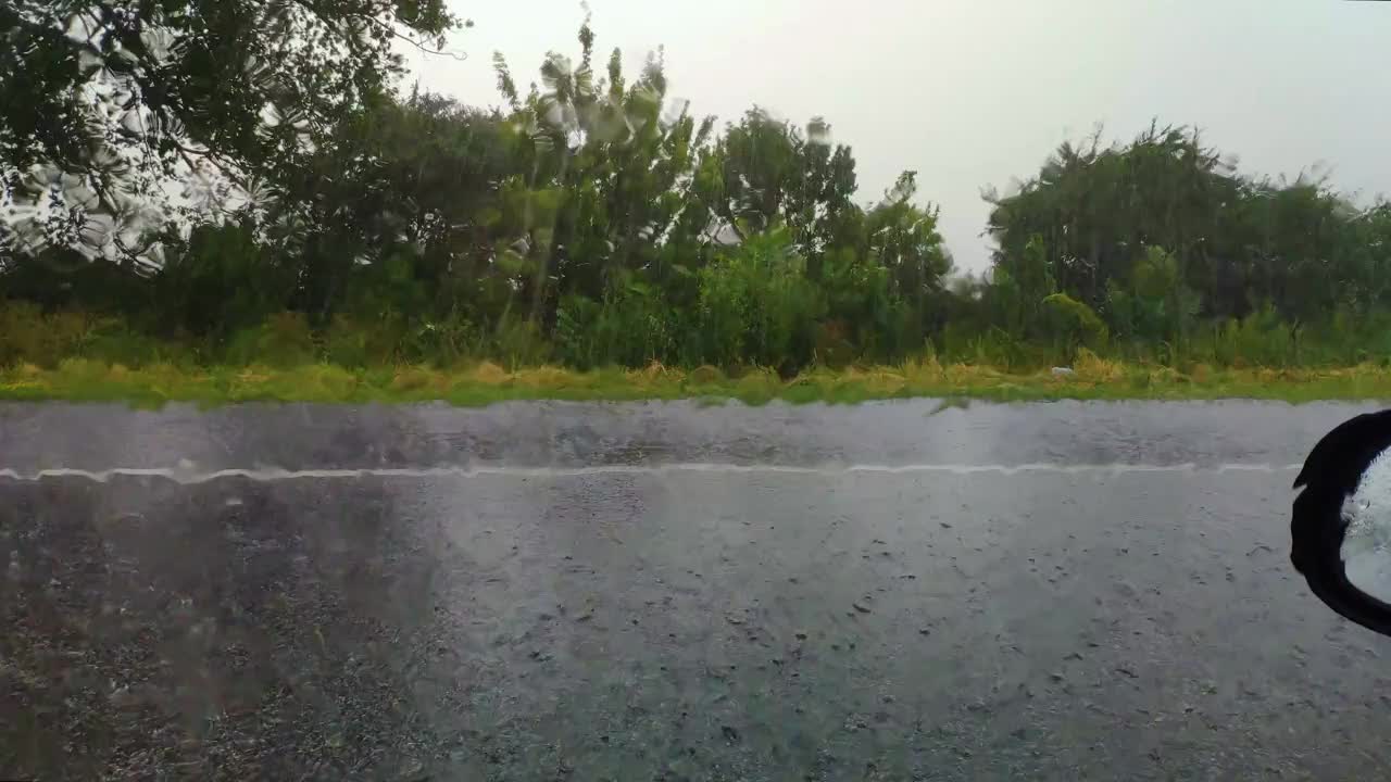 夏日大雨中过往车辆的景象。雨滴顺着玻璃流下，从汽车上看视频下载