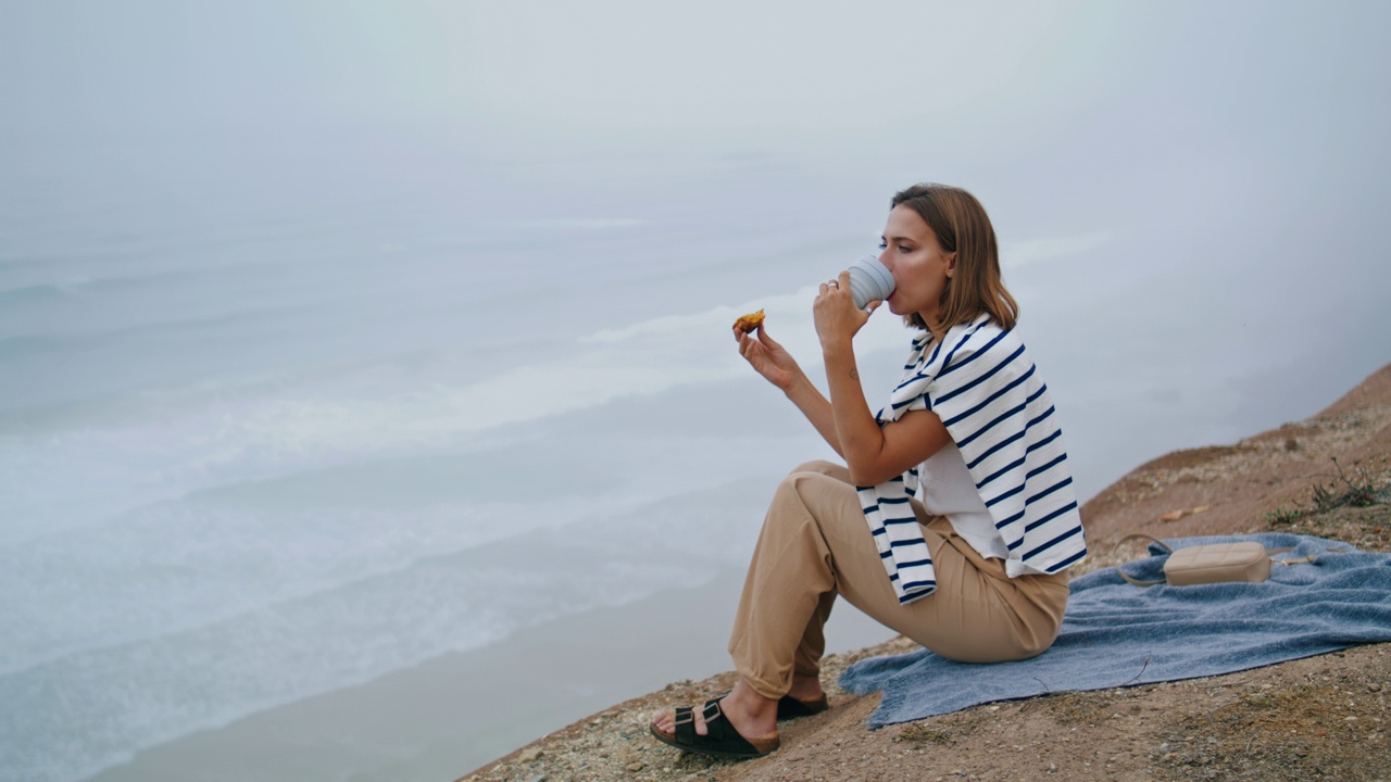 夏天的周末，女孩喝着悬崖咖啡。欣赏海景的宁静游客视频素材