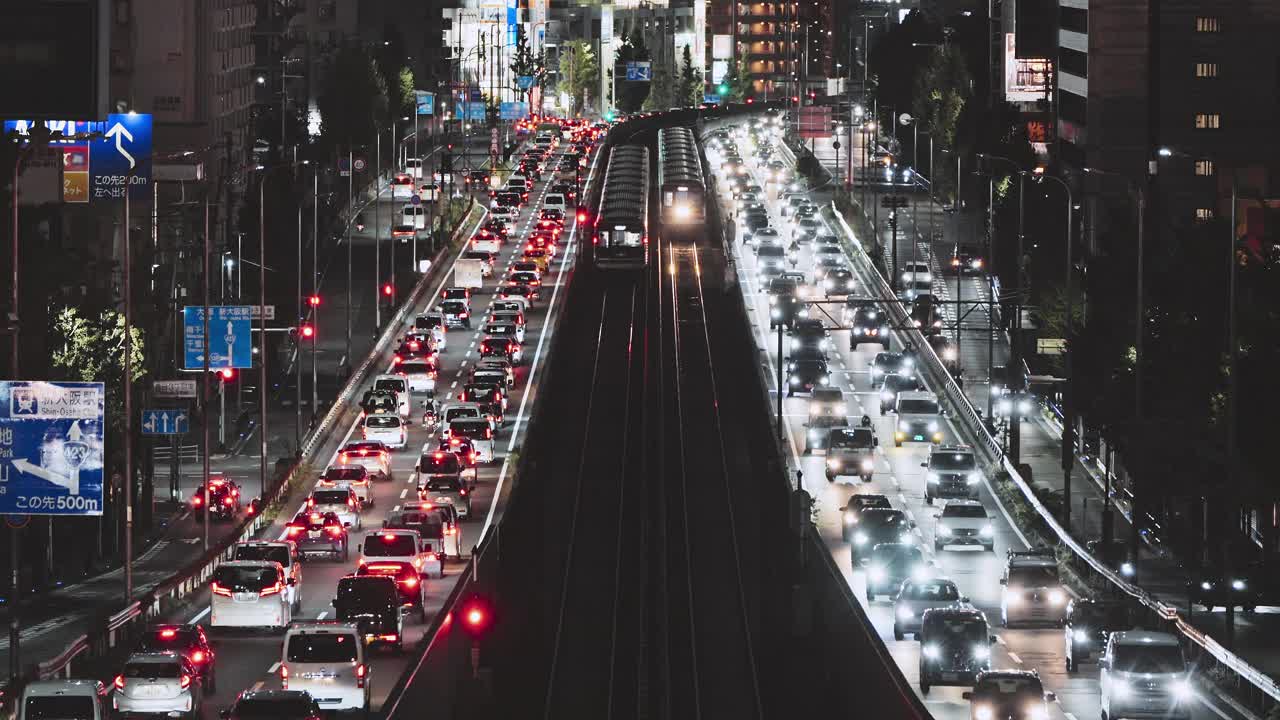 日本夜间高架公路上的汽车交通运输，铁路轨道上的通勤地铁列车。日本人的生活方式，亚洲的交通文化，亚洲的城市生活理念视频下载