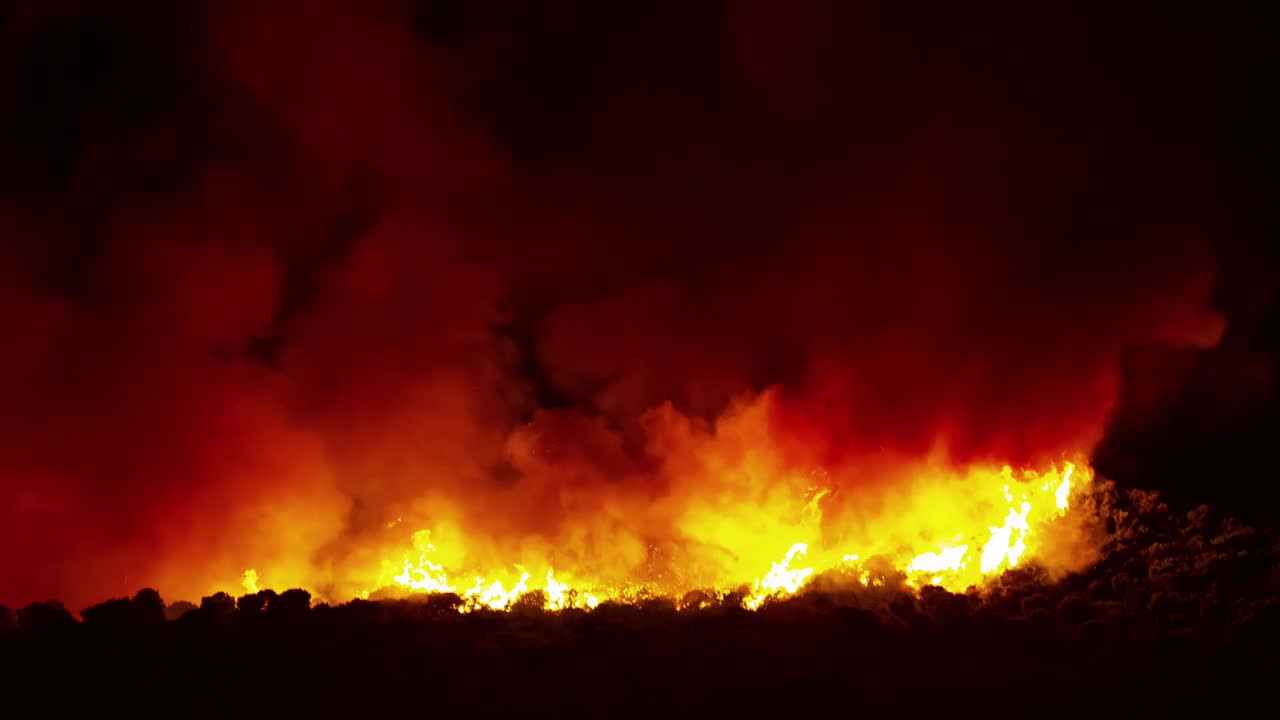 燃烧的野火在森林山脉，在黑夜中燃烧。间隔拍摄视频素材