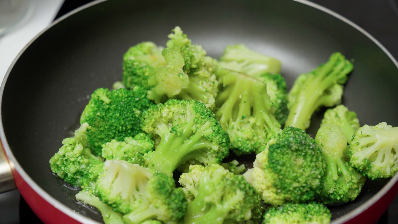 用煎锅煮西兰花(特写)。自制的健康素食食品视频素材