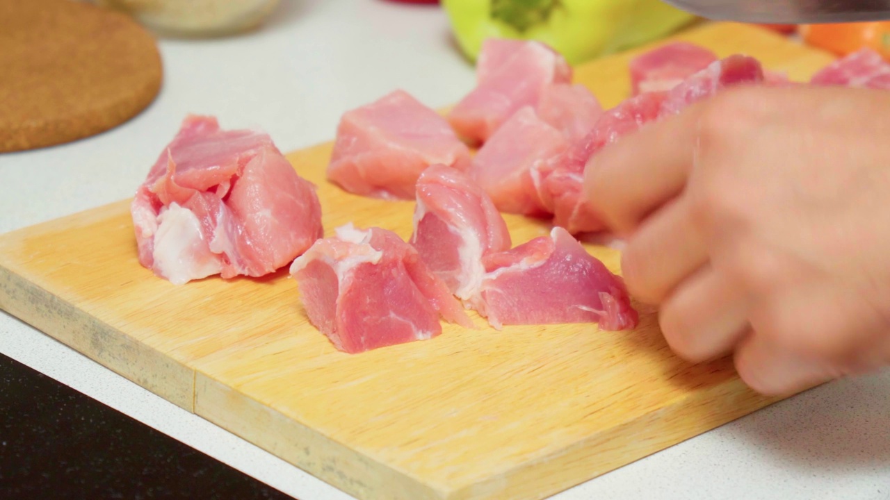 切猪肉块的男手特写。烹饪视频素材