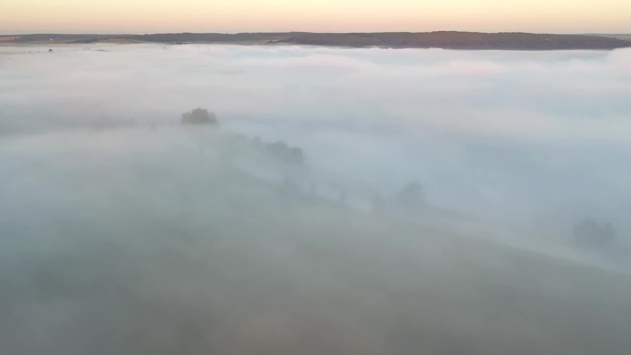 鸟瞰乡村道路和耕地的画面，刚刚被浓雾笼罩。视频下载