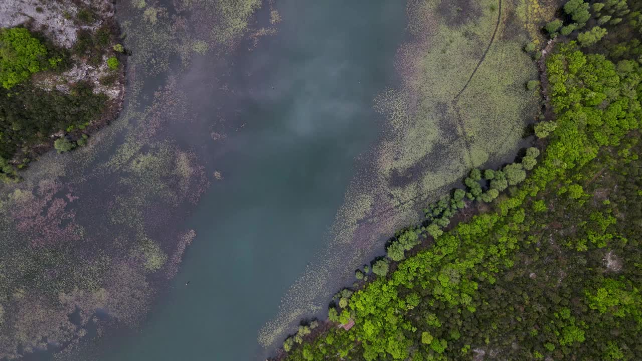 黑山国家公园的克诺耶维奇河上的蓝色山脉背景河，蜿蜒穿过山丘之间的沼泽，通往斯卡达尔湖。视频素材