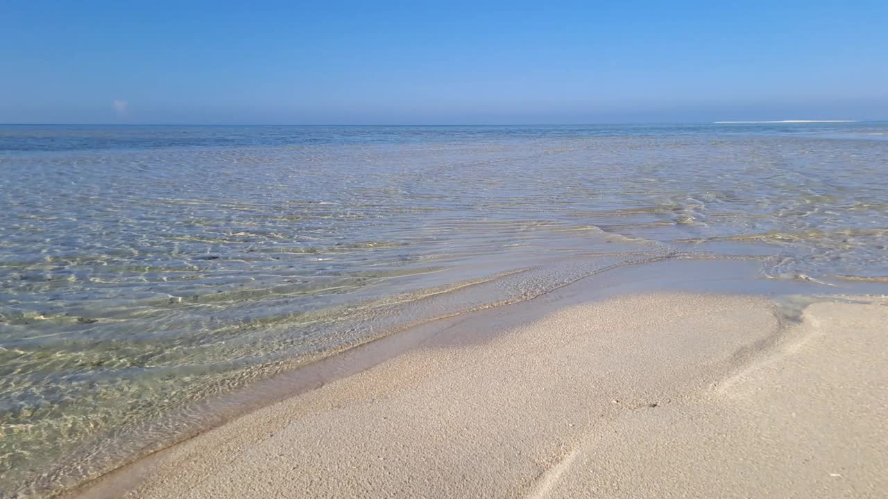 海边白色沙滩的宁静景象。迷人的海岸景色，温柔的小海浪拍打着原始的白色沙滩视频下载