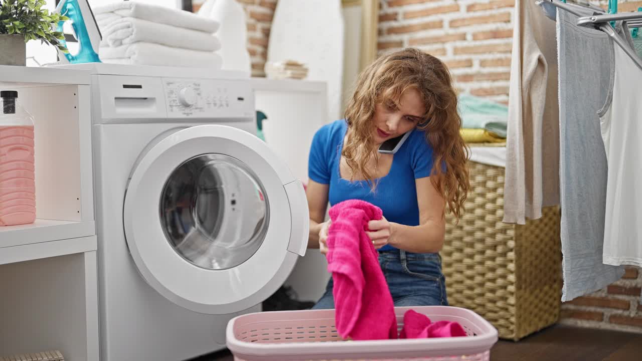 年轻女子在洗衣房用智能手机洗衣服视频素材