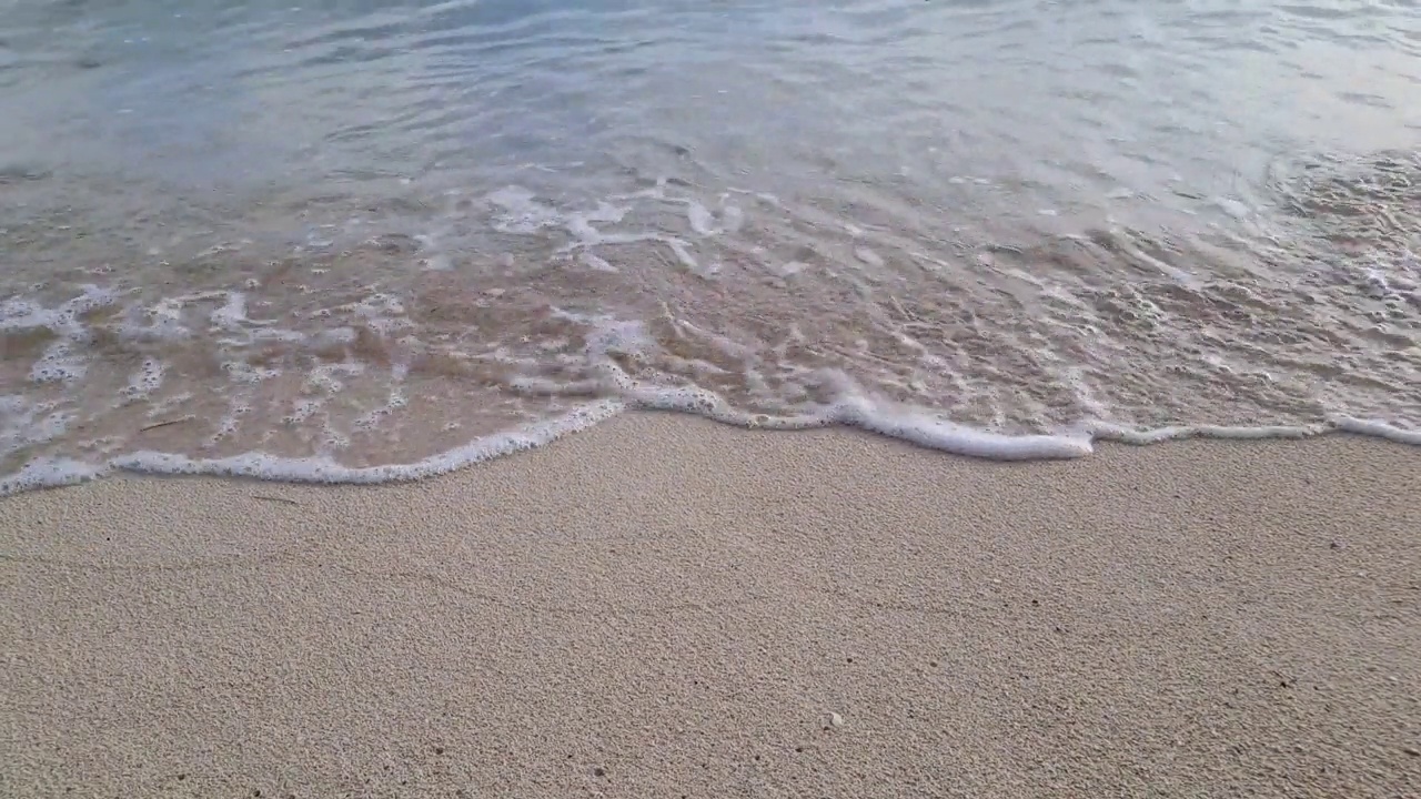 海边白色沙滩的宁静景象。迷人的海岸景色，温柔的小海浪拍打着原始的白色沙滩视频下载