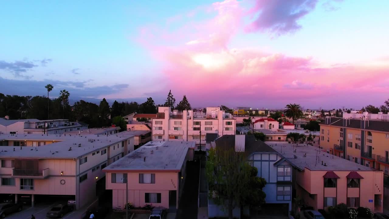 日落时多云天空下城市住宅景观上的建筑物空中向上拍摄-卡尔弗城，加利福尼亚视频素材