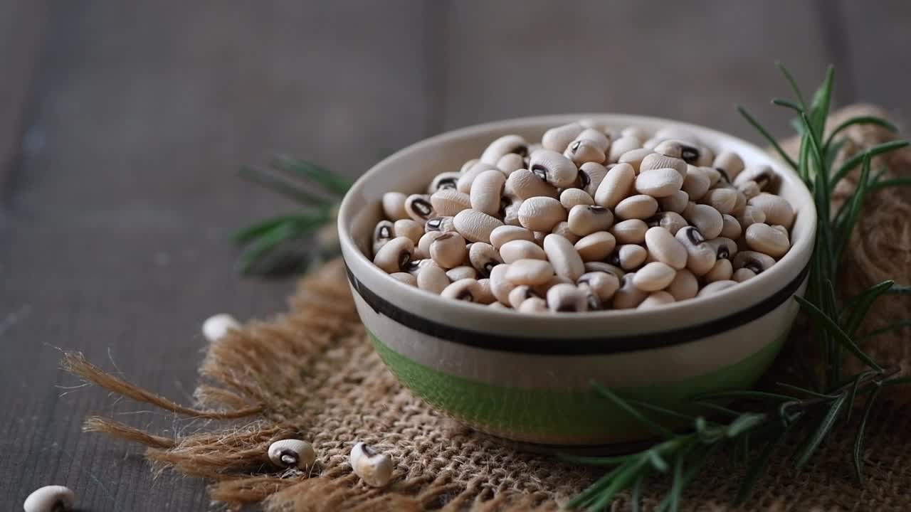 海军蓝豆或白色腰豆在木材背景。白豆是最丰富的磷脂酰丝氨酸植物来源，能降低胆固醇水平和低密度脂蛋白胆固醇。视频素材