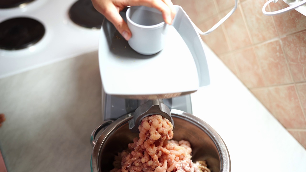 在电动绞肉机上制作肉末的妇女视频素材