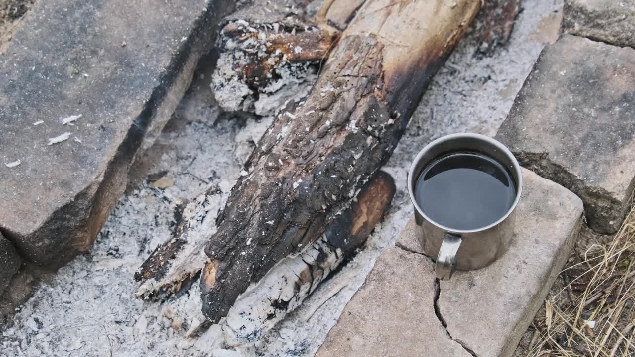 在野外篝火上自制芳香咖啡杯，特写视频素材