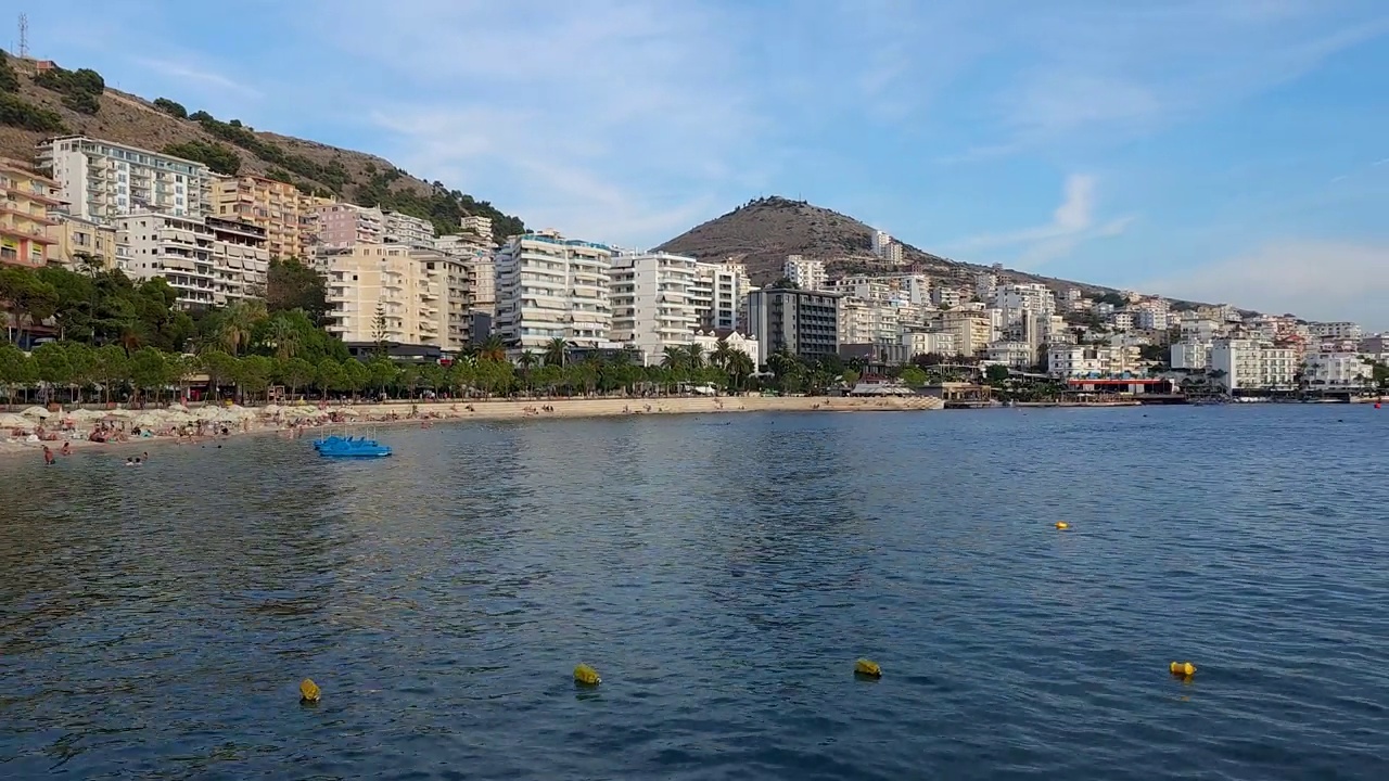 萨兰达湾的海岸美景:宁静的酒店坐落在连绵起伏的山丘与原始的蓝色大海的背景视频素材