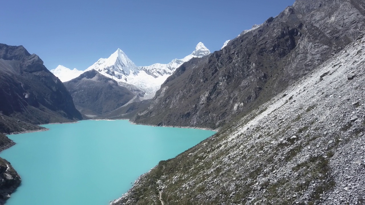 美丽的绿松石湖水在拉古纳帕隆泻湖在安第斯山脉的高山山脉在秘鲁华斯卡兰，雪山覆盖的山峰在一个明媚的阳光灿烂的一天。视频素材