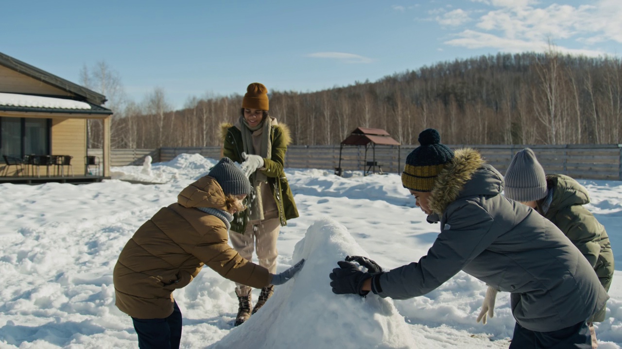 不同的青少年在后院制作雪雕视频素材