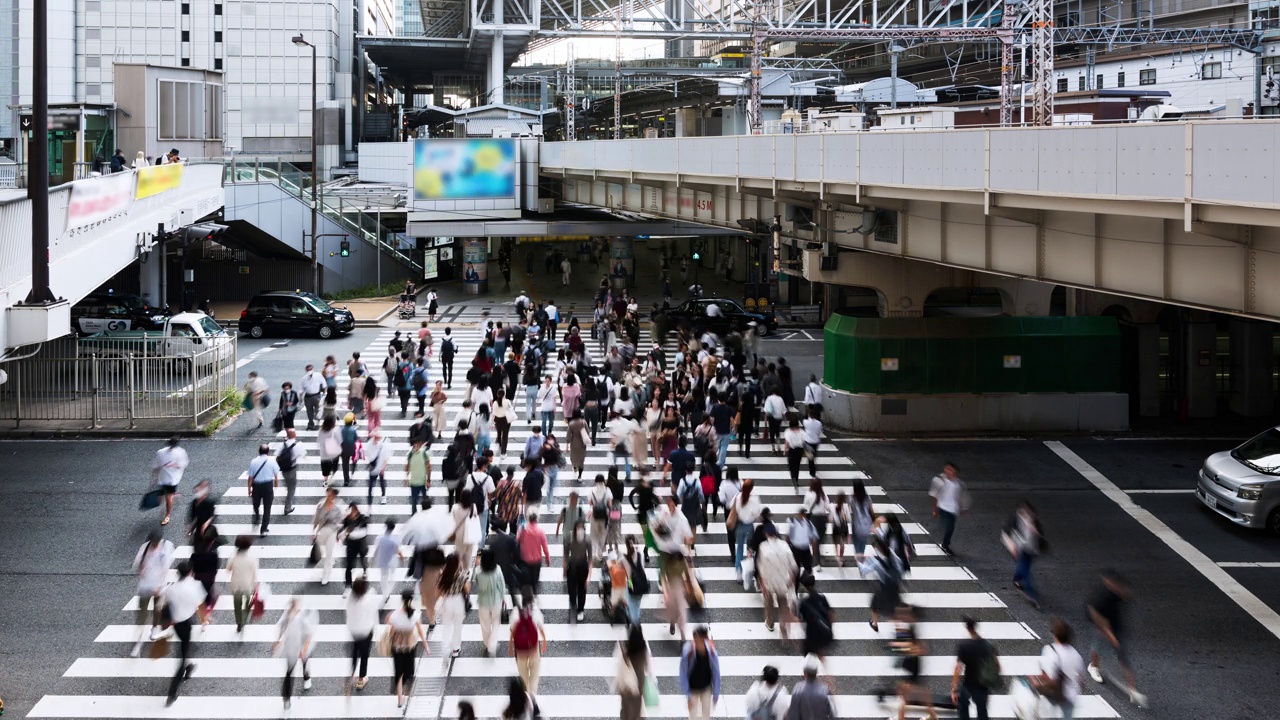 日本大阪市中心拥挤的亚洲人步行过马路、汽车和火车交通的时间轴。日本文化，城市生活方式，亚洲交通，通勤或城市生活理念视频下载