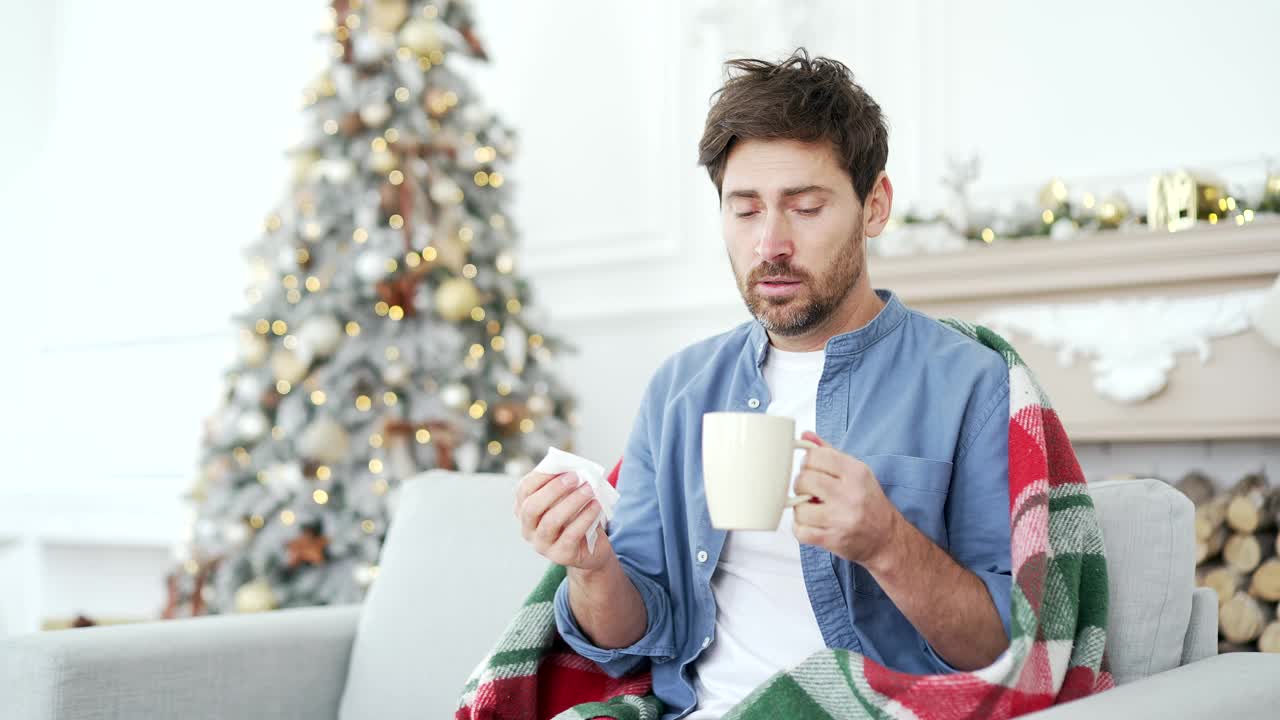 一名患感冒或流感的病人在冬季、新年、圣诞节假期坐在家里的沙发上咳嗽视频素材