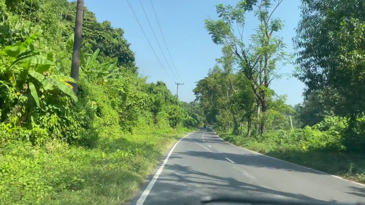 POV在山路两旁树木丛生的双车道高速公路上行驶视频素材