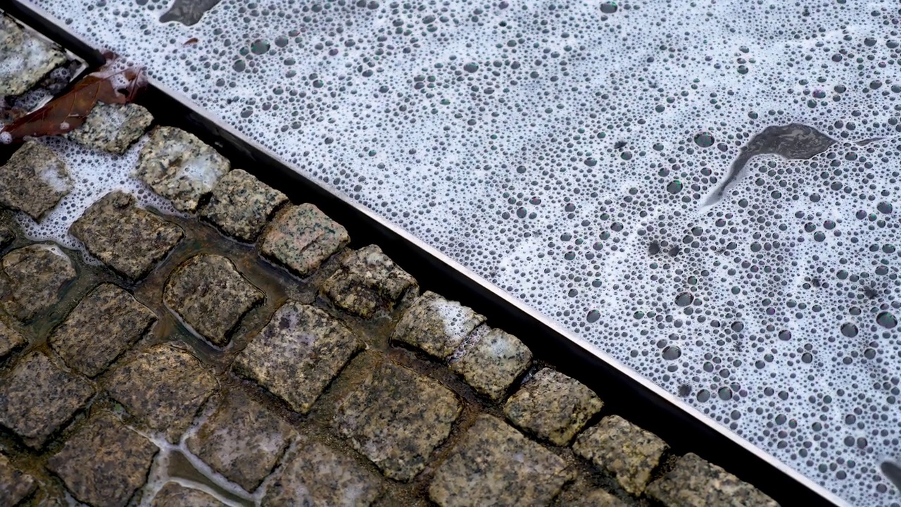 屏风对角线分为两部分:暴雨后的发泡水和潮湿的花岗石瓷砖的铺贴视频素材