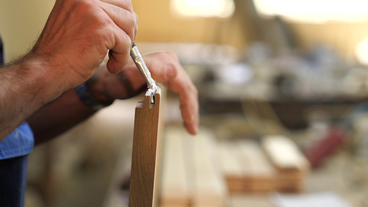 木匠用刷子把胶水涂在木制家具上视频素材