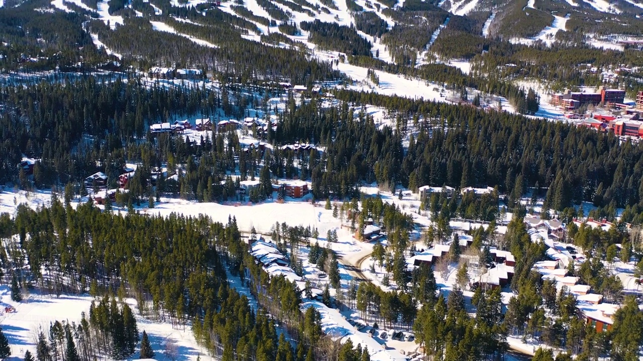 美丽的洛基山脉滑雪场。许多冬季运动的小径覆盖在山腰的山峰上厚厚的粉雪。无人机航拍画面视频素材