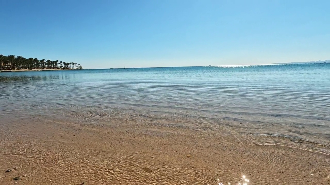 海浪轻轻地拍打着埃及宁静的沙滩。夏日沙滩、沙滩和天空的景观景观。滩海空间区。缓慢的运动。4 k视频下载