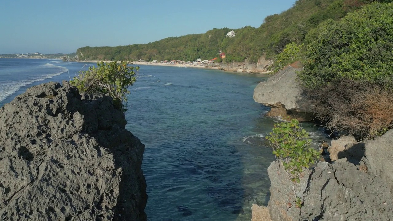 在巴厘岛乌鲁瓦图海岸外的海面上飞过岩石海堆视频素材