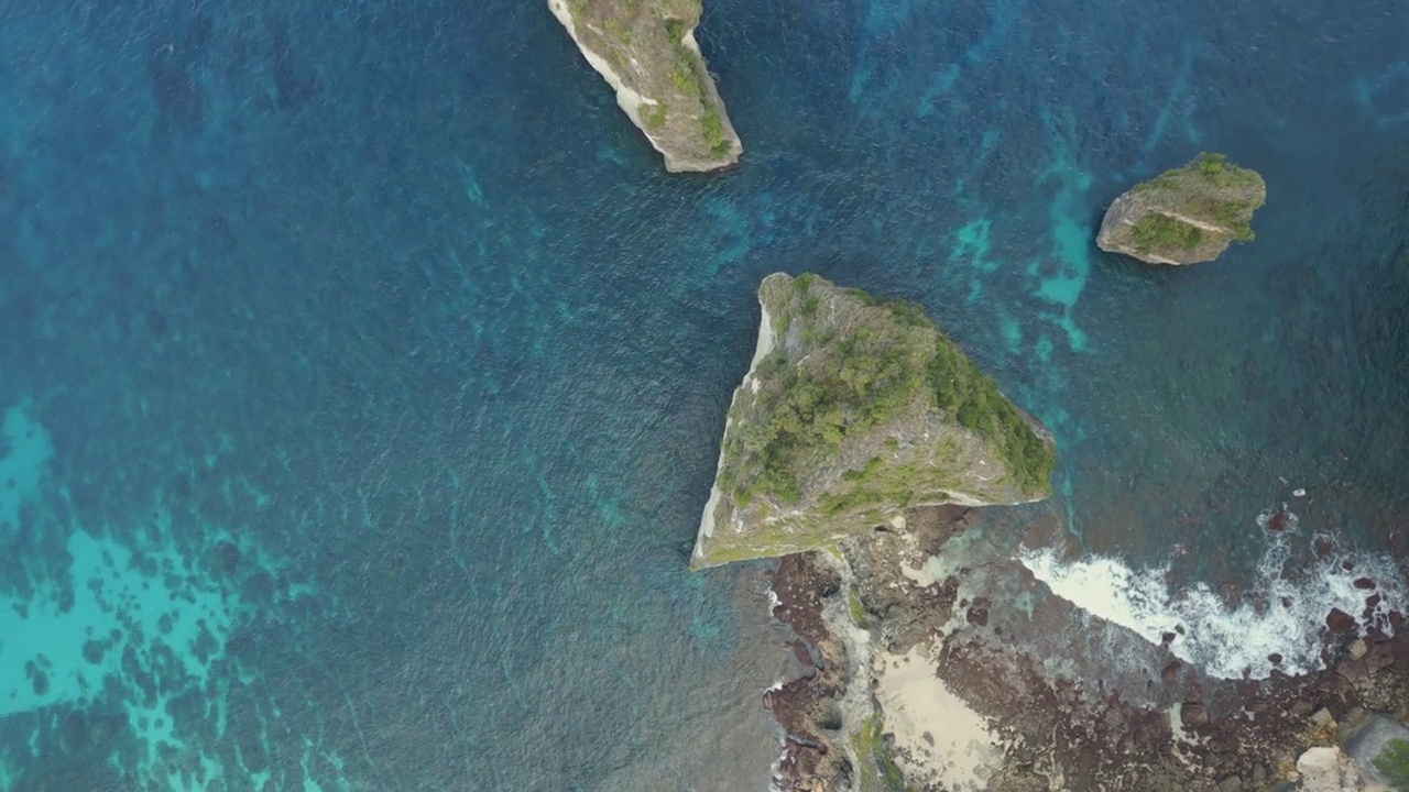 头顶旋转无人机拍摄的海堆岩层在蓝色的海视频素材