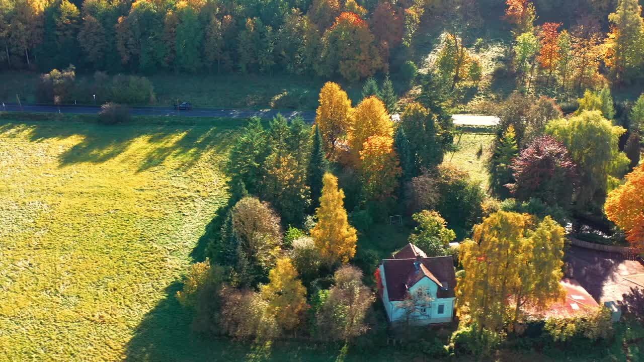 鸟瞰一个浪漫的住宅在草坪上被秋天的颜色的树木包围视频下载