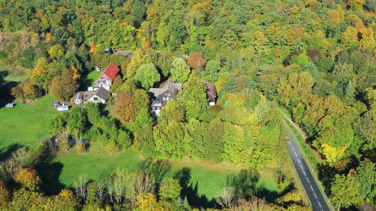 秋色森林草坪上的传统德国房屋鸟瞰图视频素材